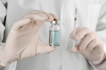 Doctor holding injection vial