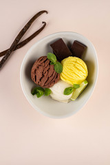Trio of tasty chocolate vanilla and lime flavored frozen dessert in a white bowl.