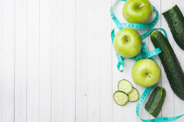 Green Apple mint cucumber on the table. The concept of diet and vegetarianism. Copy space. Measuring tape centimeter.