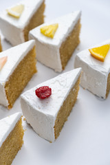 Delicious creamy minimal white cake with fruit on white background.
