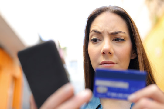 Suspicious woman pays online with credit card in the street