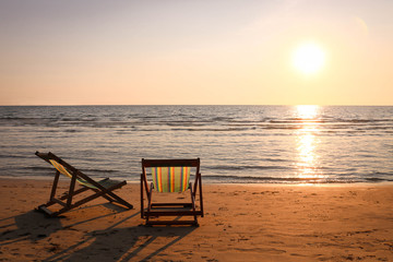 Fototapeta na wymiar Beach chair on the tropical beach at sunset time