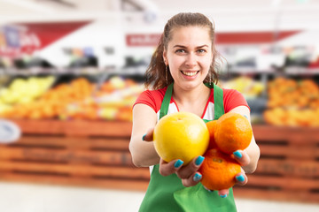 Fototapeta na wymiar Woman selling groceries presenting orange and tangerines.