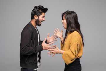 emotional young couple quarreling isolated on gray background