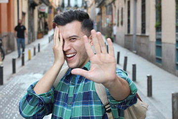 Shy man covering his face while smiling 