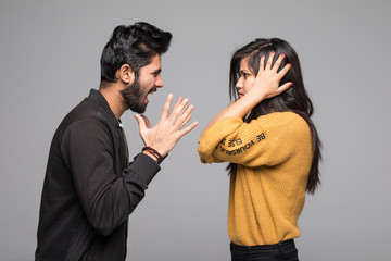 Indian young couple quarreling isolated on gray background