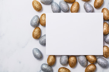 Easter background with a blank white card and glitter easter eggs