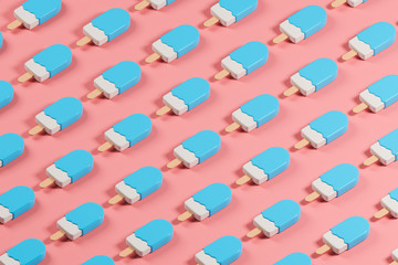 Isometric pattern made of blue glossy lolly ice cream on the pink table.