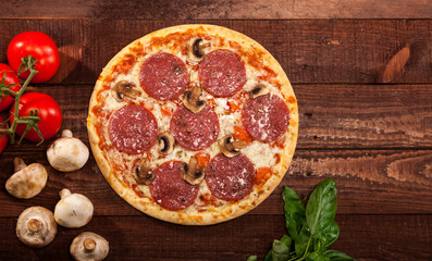 Pepperoni pizza on rustic, vintage style wood background. Top view
