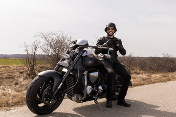 Fototapeta na wymiar Handsome man on a black classic motorcycle