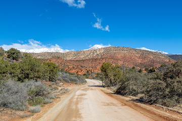 A road in remote Utah, heading towards rugged mountains