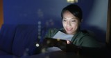 Woman play game on cellphone with window reflection