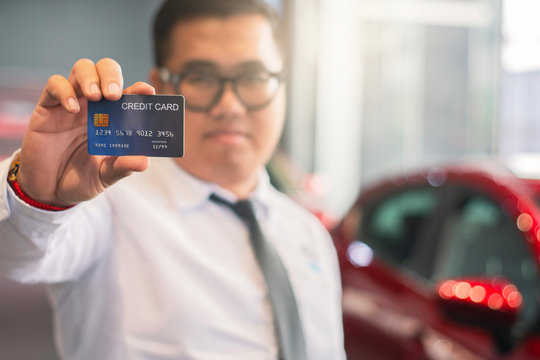 Asian man holding credit card for car blurred bokeh background e-shopping marketing digital, consumer purchase shopping internet online image