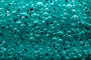 Transparent gel with bubbles close-up. The texture of gel cream. Oxygen bubbles in clear blue water, close-up. Mineral water. Water enriched with oxygen.