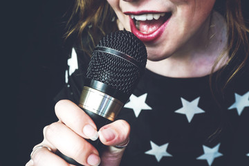 Young woman singing a song with a microphone