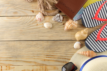 Travel concept Hat, glasses, flip flops and shells on a natural wooden table. relaxation. holidays. top view. free space