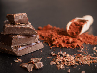 Stapel von Schokolade mit Kakao auf einem dunklen Hintergrund, Nahaufnahme