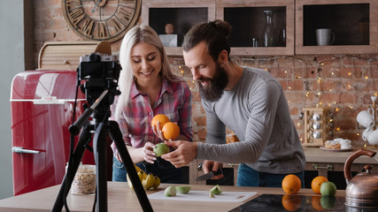 Vlog on organic food. Healthy nutrition blog. Young couple cutting fruit. Video recording at...