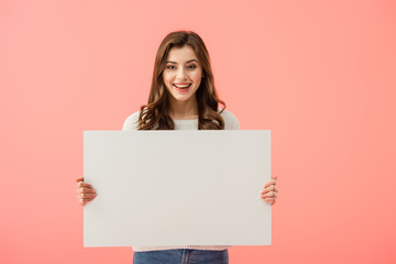 smiling and attractive woman holding empty board with copy space isolated on pink