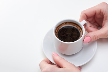 Woman's hands holding cup of espresso, white background, copy space