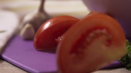 Sliced pieces of tomato falling close-up. Scene. Pieces of tomato fall