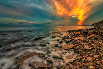 Amazing clouds like fire in the sky over the sea coastline