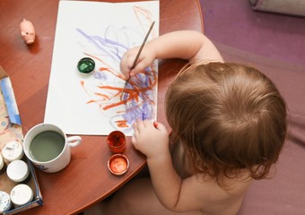 Child with paintbrush and paint 