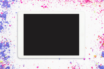 Touchpad with blank screen on colorful crumbled eyeshadows on white background. Touchscreen pc on white makeup background. Flat lay