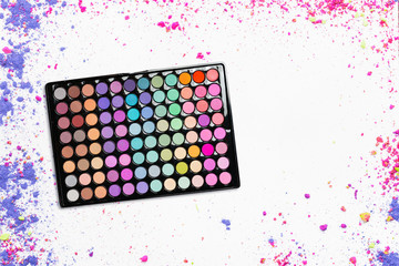 Сolorful eyeshadow palette with crumbled eyeshadows on white background. Flat lay. Top view