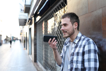 Guy using voice recognition on smart phone outside