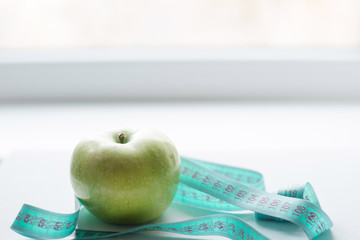 Green apple with measuring tape isolated on white background.Diet concept.place for text. copy space.