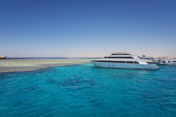 Obraz na płótnie Canvas Luxury yacht docking near coral reef
