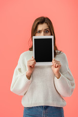 Fototapeta premium confused young woman holding digital tablet with blank screen isolated on pink
