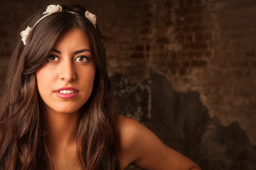 Fototapeta premium pretty brunette girl sitting on leather sofa with brick wall background
