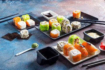 Traditional Japanese food- sushi, rolls, chopsticks, soy sauce on color stone background. Sushi menu.