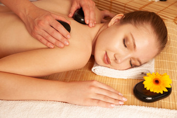 Plakat Beautiful young woman having a massage treatment in spa salon - wellness