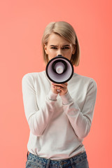 Fototapeta premium blonde young woman speaking in megaphone isolated on pink