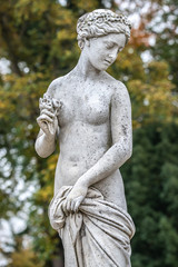 Fototapeta na wymiar Statue of sensual naked Greek renaissance era woman with flowers, Potsdam, Germany, details, closeup