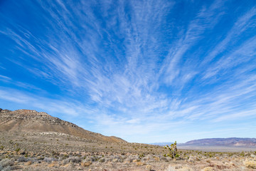 Looking out over a vast Nevada landscape with clouds and blue sky overhead