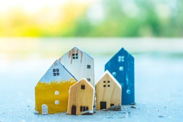 Closed up tiny home models on sand with sunlight and beach.