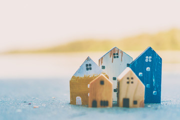 Obraz na płótnie Canvas Closed up tiny home models on sand with sunlight and beach.