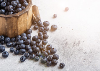 Fresh raw organic blueberries in vintage wooden box on stone kitchen background. Food concept