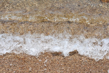 Beautiful soft waves of Blue Ocean with Sandy Beach Background close up. Sea sand wallpaper