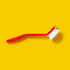Bright red brush lies on a bright yellow background. In the style of pop art. Top view. Copy space.