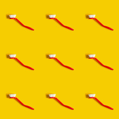 Bright red brush lies on a bright yellow background. In the style of pop art. Top view. Copy space.