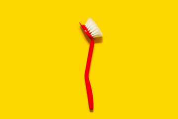 Bright red brush lies on a bright yellow background. In the style of pop art. Top view. Copy space.