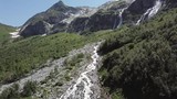 Aerial view of mountain landscape. Aerial view of mountains covered forest, trees with flowing river, against the sky and clouds