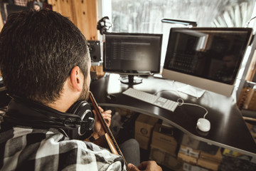 Man playing guitar in a recording studio. Concept guitarist composing music