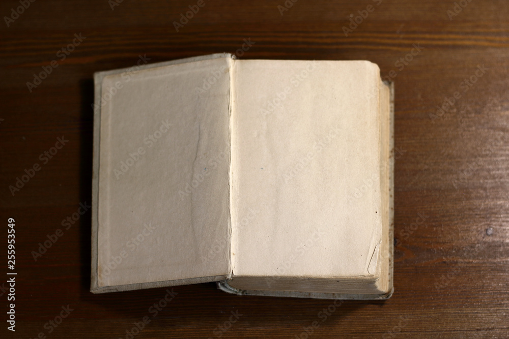 Fototapete An open old retro book with white blank empty pages on which the designer can write a greeting text or a postcard on the wooden background of the library atmosphere