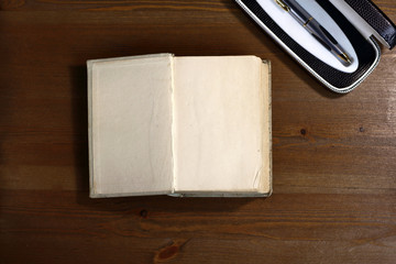 Open old retro book with blank empty pages next to pen with free copy space for text background of the library atmosphere